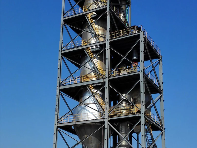 Dye spray granulation tower with steel platforms and yellow safety railings