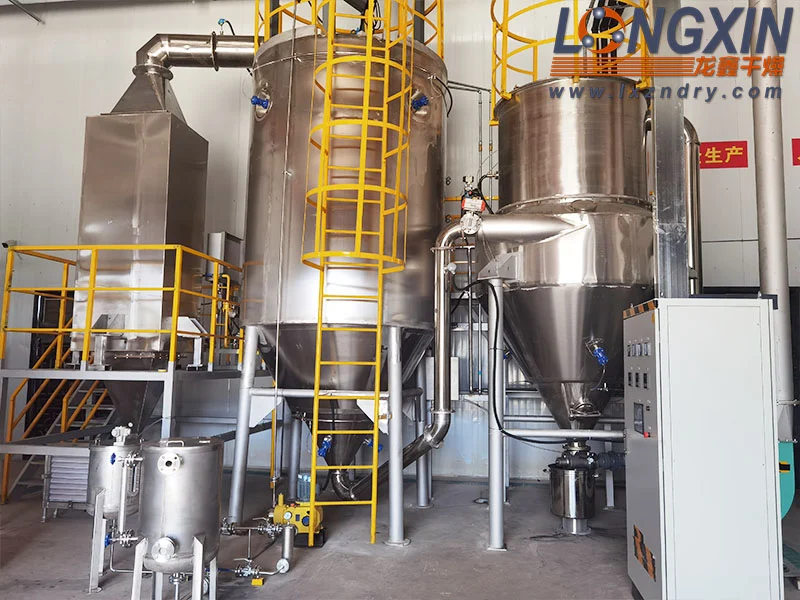 Fluid nozzle spray dryer configuration for atomizing liquid feed with compressed gas.