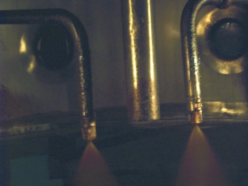 Two pressure spray nozzles atomizing liquid inside a drying chamber